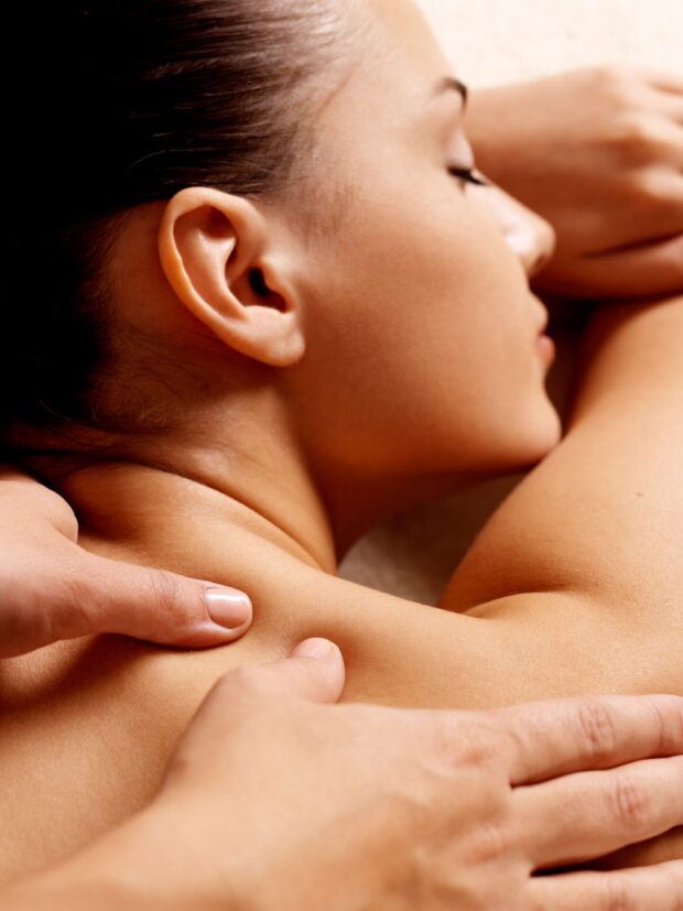 Masseur doing massage on woman body in the spa salon. Beauty treatment concept.